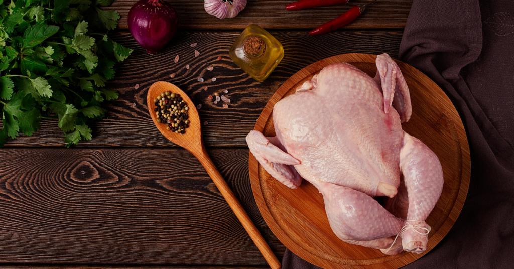 A whole chicken ready for roasting, trussed and seasoned.