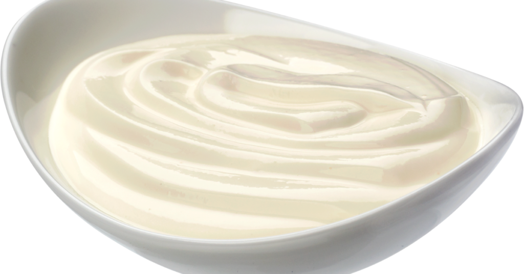 A bowl of Greek yogurt used for marinating roast chicken.